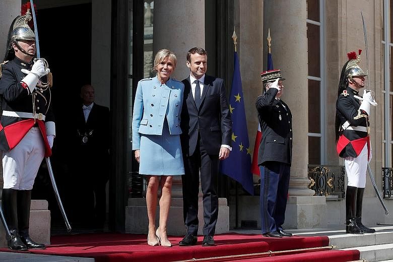 French President Emmanuel Macron, 39, and his wife, Ms Brigitte Trogneux, 64, on the steps of the Elysee Palace in Paris yesterday after the inauguration ceremony. The centrist newcomer stands outside any traditional political grouping and is a Europ