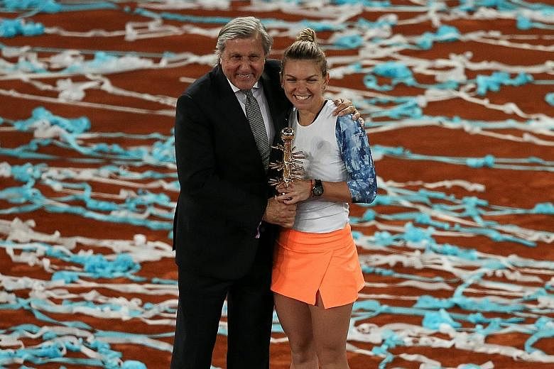 Simona Halep posing with her Fed Cup coach Ilie Nastase after winning her second straight Madrid Open title. Nastase is banned from the French Open and Wimbledon after a series of foul-mouthed rants last month.