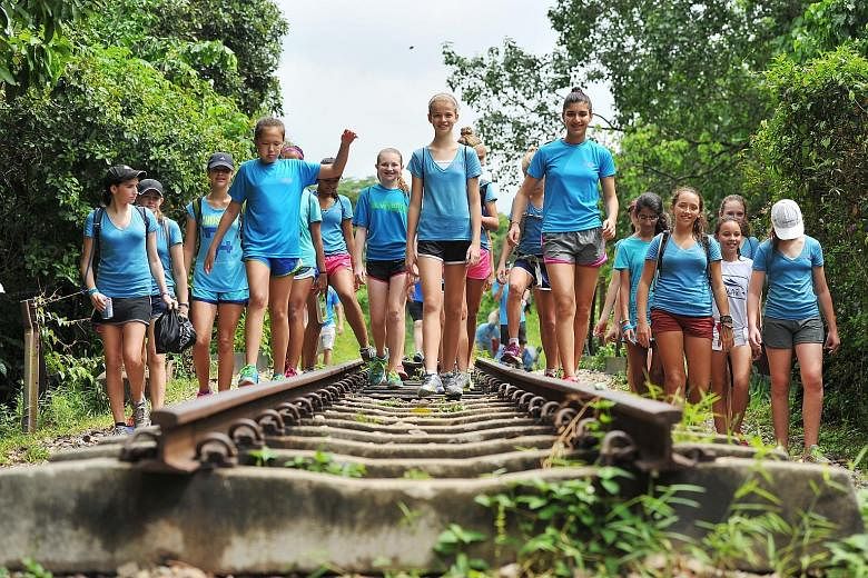 Bryanna (centre), flanked by Sabrina (right) and Sophie, walking along the green corridor in 2014. The three Singapore American School students started the initiative in 2013. Altogether, the charity walk has raised over $100,000, not inclusive of this ye
