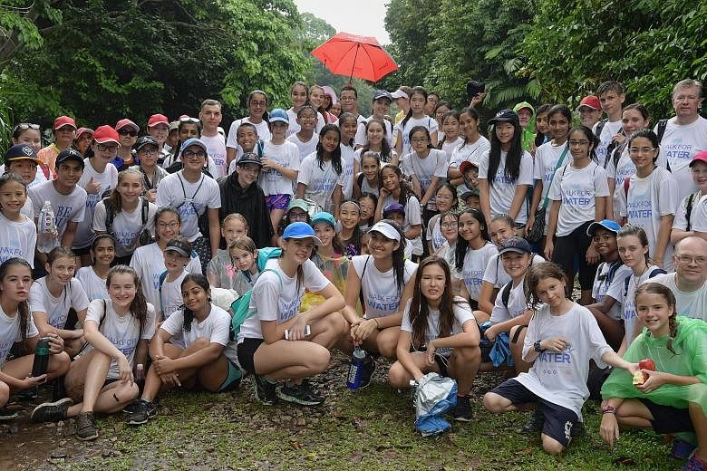 Walk for Water co-founders Bryanna Entwistle (foreground centre, wearing blue cap), Sabrina Sain (white cap) and Sophie Wirt (wearing earphones) with some of the 170 people who walked 28km along the green corridor as part of a fund-raising effort to build