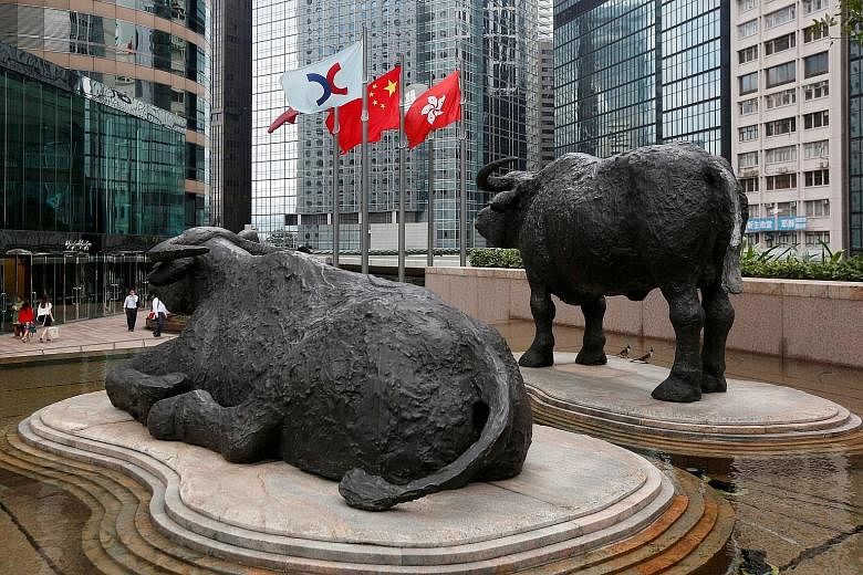 Sculptures outside the stock exchange of Hong Kong. In the past year, the number of Singapore-listed and private companies exploring a Hong Kong IPO has "doubled" to over a dozen, said auditing firm PwC.