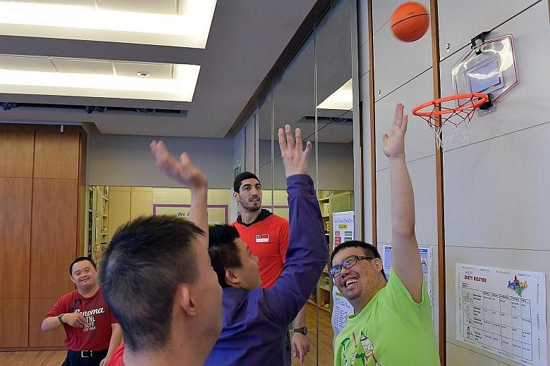 Oklahoma City Thunder's Enes Kanter watching members of the Down Syndrome Association Singapore shooting hoops at its Bishan centre. The Turkish NBA player engages in philanthropy through his foundation.