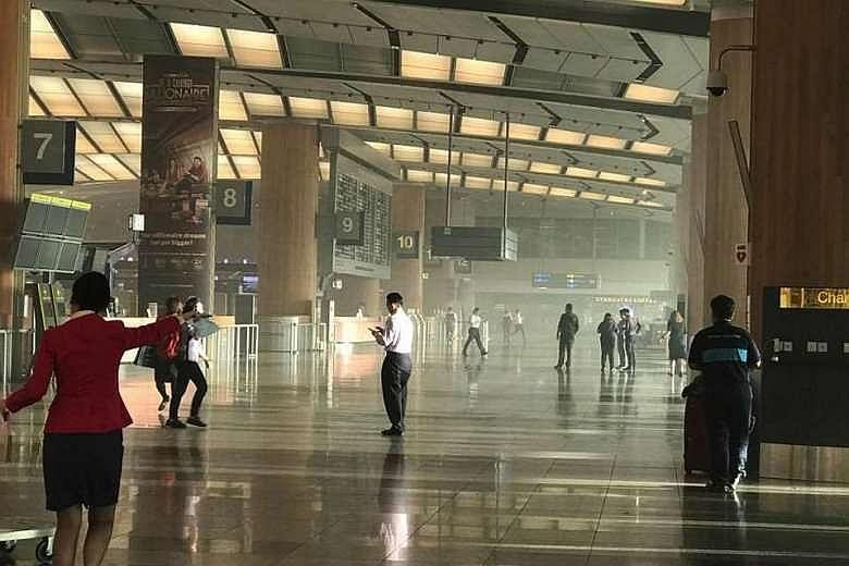 Smoke at Changi Airport Terminal 2 yesterday. Thousands of departing passengers ended up being delayed, some for more than three hours, following the fire. Passengers waiting outside Changi Airport Terminal 2. While some complained about the long wai