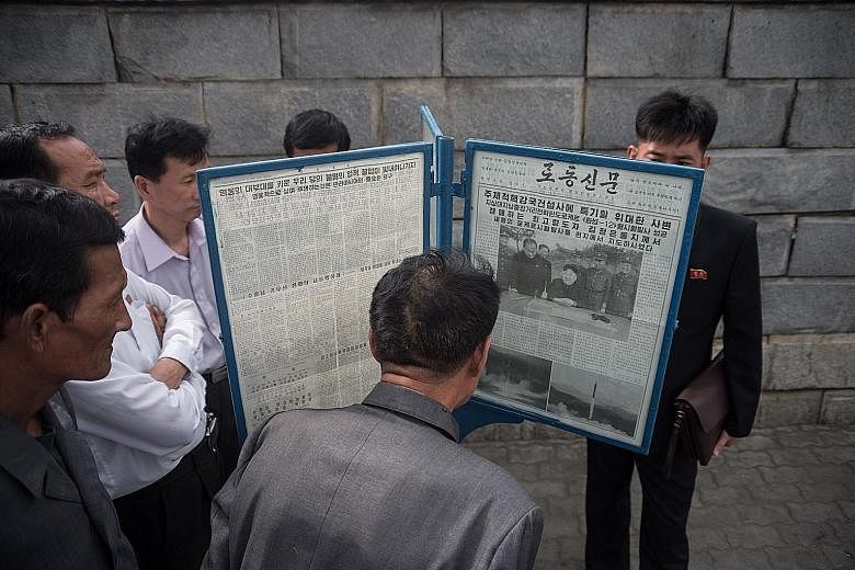 North Koreans reading news reports on Monday about their country's latest ballistic missile test, which was carried out on Sunday. The rocket, which Pyongyang dubbed the Hwasong-12, marks a significant milestone in its development of an intercontinen