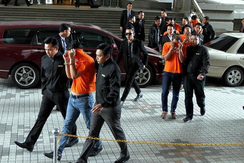 Suspects in the Malacca case being led away from the Magistrate Court in Putrajaya yesterday. Two district police chiefs in Malacca, as well as an inspector, were arrested for allegedly getting payments from illegal gambling dens and massage parlours