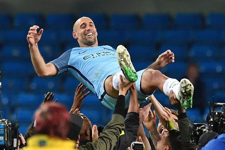 Pablo Zabaleta is thrown in the air by team-mates after the 3-1 win over West Brom, which marked the Argentinian's last home game in City's colours. He won the Premier League twice with them.