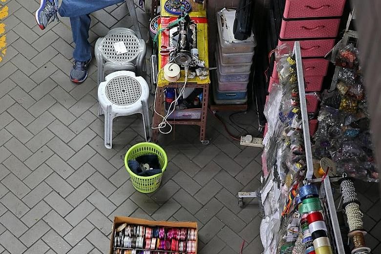 A shopkeeper selling ribbons, laces and buttons at a shop in Old Woodlands Town Centre. Some elderly people work for social connectedness and fulfilment, but many others say they have to work because they need the income.