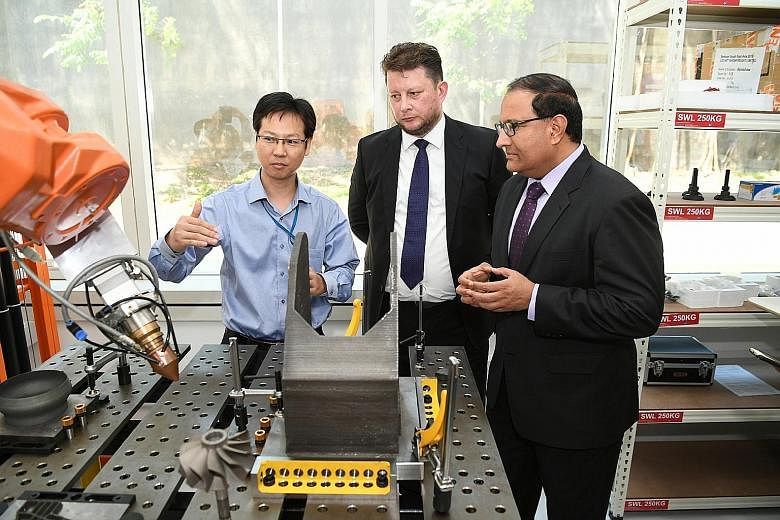 Chief executive officer of 3D Metalforge, Mr Matthew Waterhouse, and Minister for Trade and Industry (Industry) S. Iswaran yesterday during a tour of the facility, which will make parts for the marine and offshore, oil and gas, manufacturing, enginee