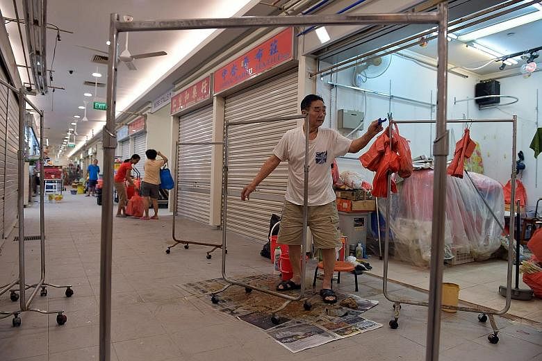Mr Lee Chia Lim, 81, who has been selling ladies' wear for 50 years at the Tiong Bahru market, readies his stall for the market's reopening. Not everyone will be back in business tomorrow though, as some stall holders said they needed more time to ge