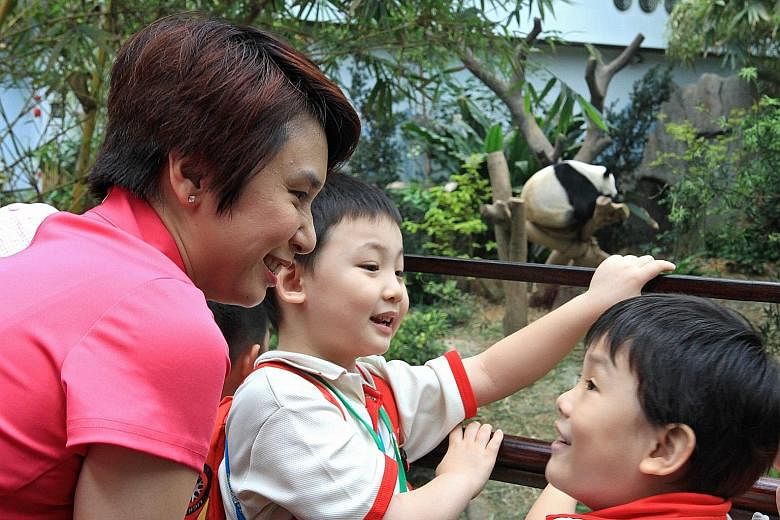 Ms Low Yen Ling with Zhang Bao Wen (centre) and Li En Xu from PCF Sparkletots Preschool watching Kai Kai in the panda enclosure.
