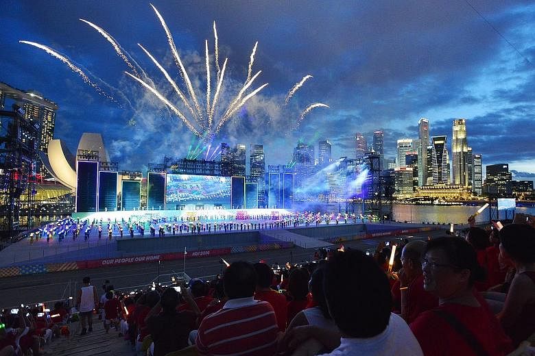 Spectators enjoying a brilliant fireworks display during the National Day Parade at The Float @ Marina Bay on Aug 9, 2014.