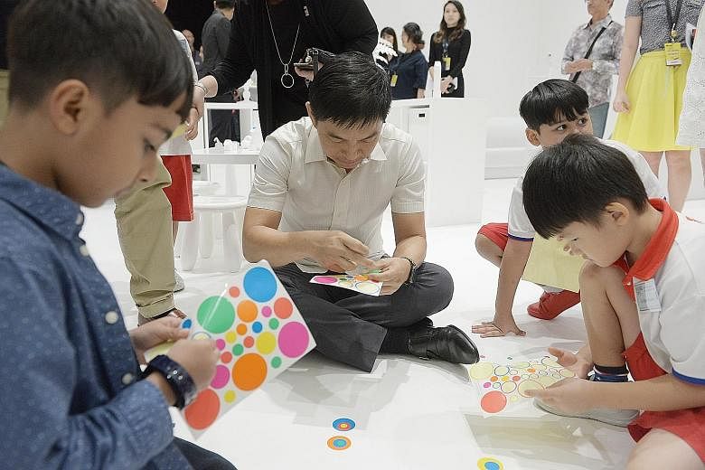 Social and Family Development Minister Tan Chuan-Jin pasting sticker dots in The Obliteration Room, created by artist Yayoi Kusama, at the opening of National Gallery Singapore's inaugural Gallery Children's Biennale yesterday. Visitors are invited t