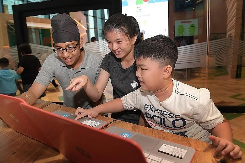 Keeret Singh Sandhu, 13, Celeste Low, 15, and Matthew Chua, 10, demonstrating their coding ability at the Google office in Pasir Panjang yesterday after completing a 10-week module.