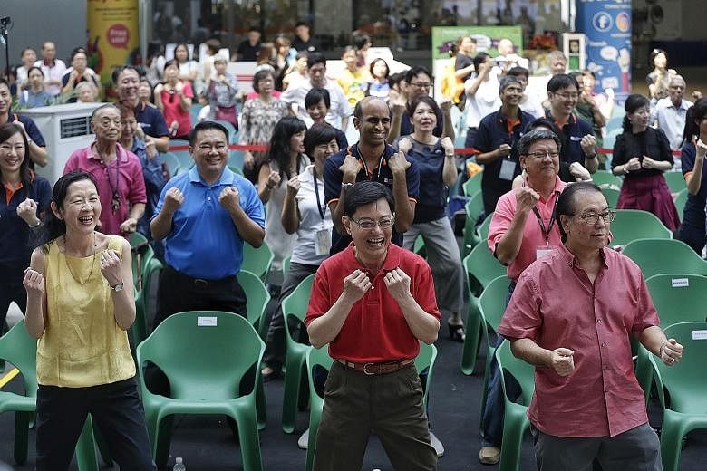 Finance Minister Heng Swee Keat (centre) in a mass exercise session yesterday. Flanking him are Singapore Health Services Group CEO Ivy Ng and Singapore Health Services chairman Peter Seah.