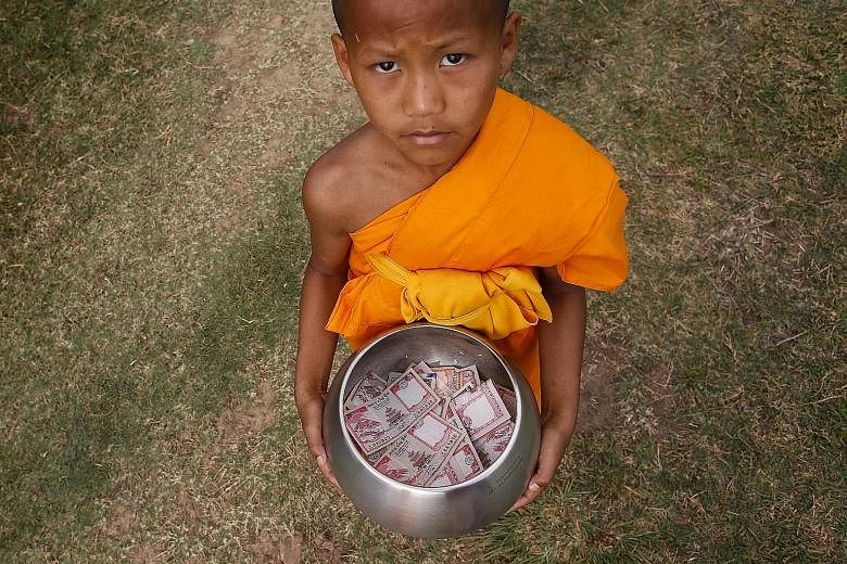 A Nepalese Buddhist monk collecting donations in Lumbini, Nepal. Through experiments, the writers believe that rich people are more likely to donate if the call to action is focused on the individual.