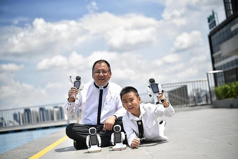 Dr Paul Zhang and his son Emiliano with the 24cm-tall GT Wonder Boy. The robot can converse in 13 languages, recognise voices and faces, do mathematics, dance and sing. And it can also do what a regular smartphone does, including taking photos.