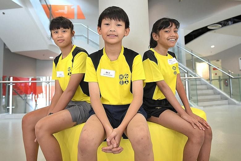 (From left) Meagan Lim, 12, Isaac Ong, 11 and Amirah Fikriyah Herman, 11, were among the first cohort of students under the revised Junior Sports Academy (JSA) programme to graduate yesterday.