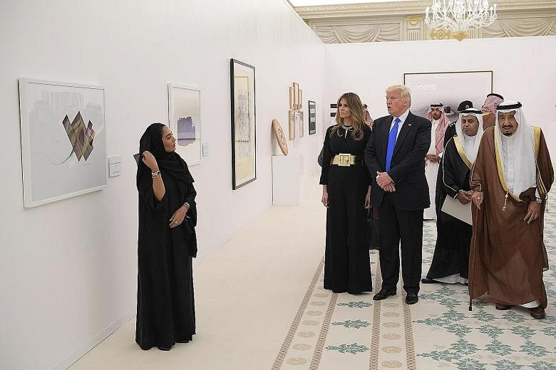 Ms Ivanka Trump at the Saudi Royal Court in Riyadh yesterday with her husband and senior White House aide Jared Kushner. Above:Mr Donald Trump and First Lady Melania looking at a display of Saudi modern art in the Saudi Royal Court with Saudi King Sa