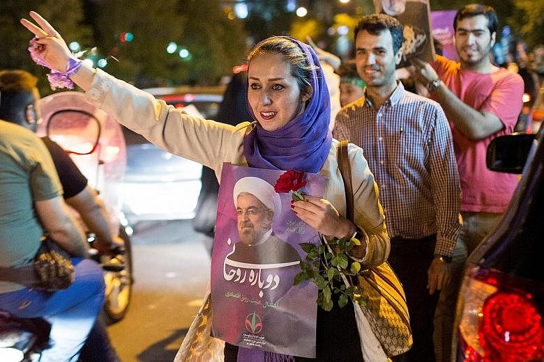 A supporter of President Hassan Rouhani carries his poster during a rally in Teheran on Wednesday. He had campaigned as a reformist and challenged Iran's powerful security force, IRGC.