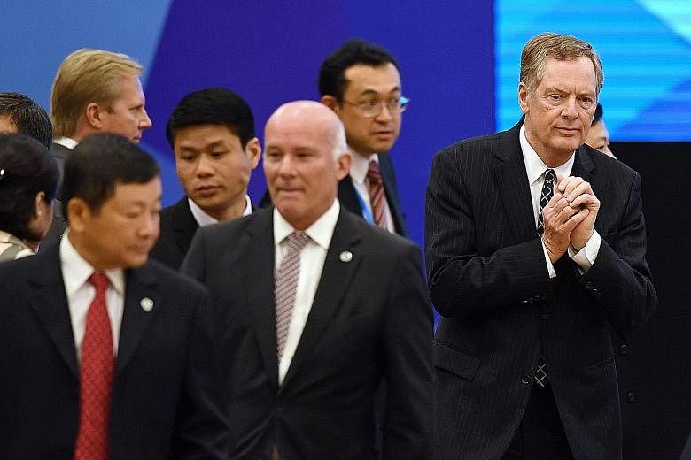 US Trade Representative Robert Lighthizer (right) enters a meeting room to attend the Apec trade ministers' meeting at the National Convention Centre in Hanoi yesterday. He will have individual meetings with counterparts from some of Washington's mos