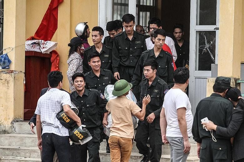 Policemen who were held hostage by Vietnamese villagers over a land dispute being released from the Dong Tam communal house, on the outskirts of Hanoi, last month. A land-dispute protest in Dong Tam on April 20. The banner reads: "The people of Dong 