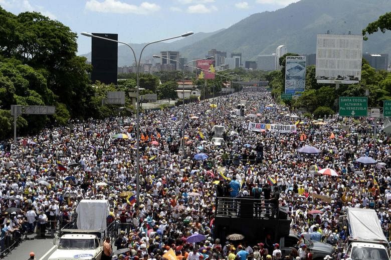 Demonstrations against the unpopular Maduro government continued on Saturday, with protesters clashing with riot police in Caracas (above) even as opposition activists blocked the city's main motorway (right). Angry Venezuelans battled on despite ons