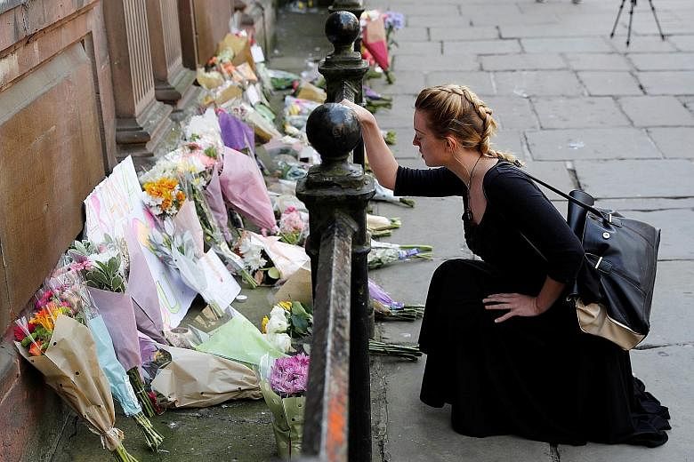A woman laying flowers for the victims of the Manchester Arena attack in central Manchester yesterday.