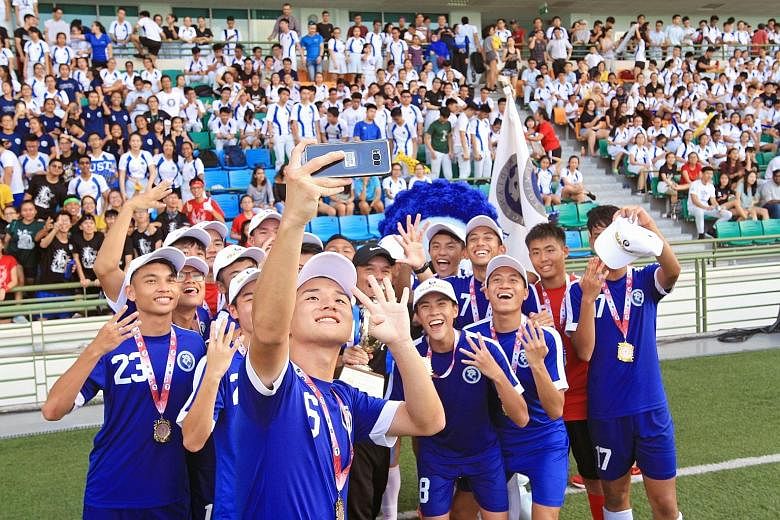 Meridian Junior College's Hong Seung Jun taking a celebratory wefie with the rest of the team, as they raise four fingers to indicate their fourth consecutive win in the Schools National A Division boys' football competition after beating VJC. MJC's 