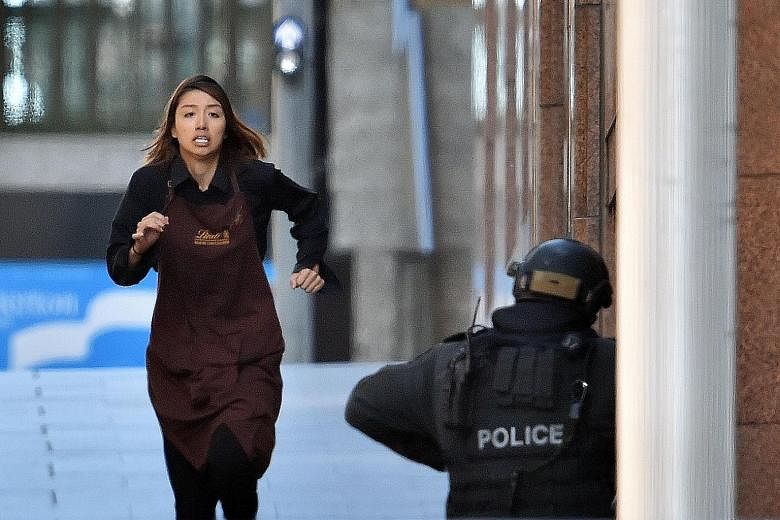 A hostage fleeing the Sydney cafe during the siege in December 2014. The siege left two hostages and the gunman dead.