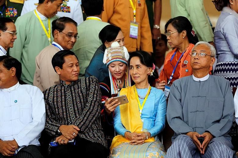 An ethnic woman tries to take selfie with Myanmar's Aung San Suu Kyi after the opening ceremony of the peace conference, the second round of peace talks since her civilian government came to power. Flanking her are Myanmar President Htin Kya (right) 