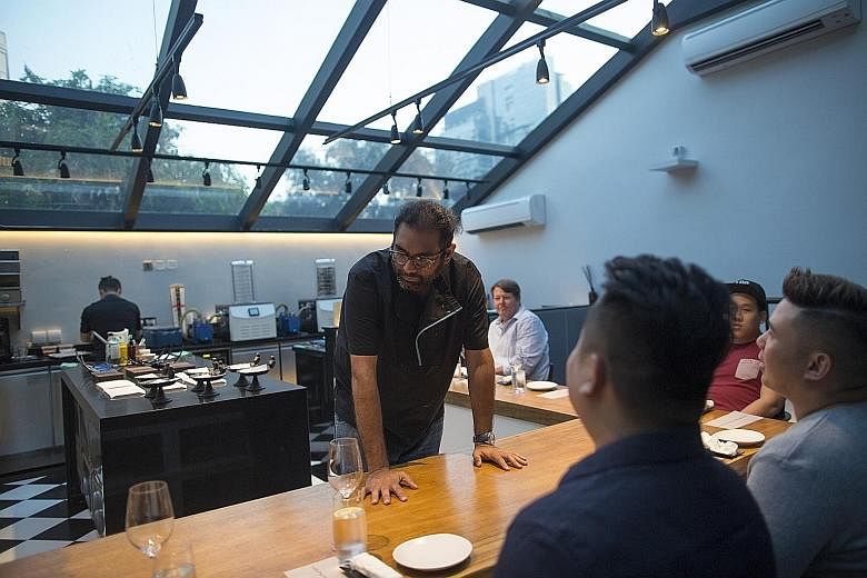 Chef Gaggan Anand with customers at the chef's table inside the research and development kitchen at his restaurant in Bangkok.