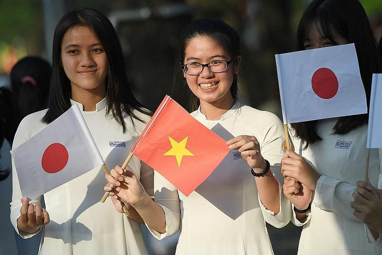 Students waiting on a street in Hue, Vietnam, to welcome Japan's Emperor Akihito and Empress Michiko during their March visit.