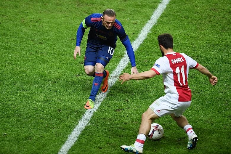 Manchester United captain Wayne Rooney in action against Amin Younes of Dutch side Ajax during the Europa League final on Wednesday. United won 2-0 to secure their third title of the season, after also winning English football's Community Shield and 