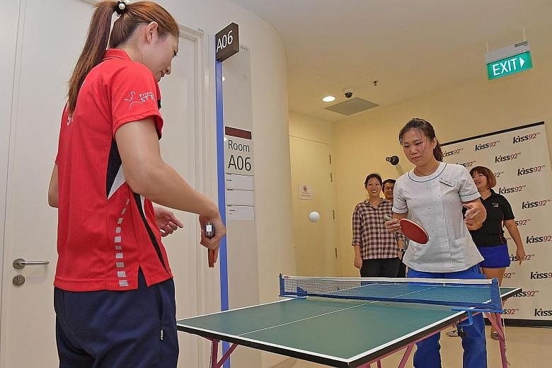 Yu Mengyu having fun sparring with a nurse at the National University Hospital's Children's Cancer Centre yesterday, as national paddlers continue their tradition of doing community work before they leave for the World Table Tennis Championships, hel