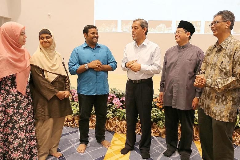 From right: Wakaf Disbursement Committee chairman Sallim Abdul Kadir, Mufti Fatris Bakaram and Muis chief executive Abdul Razak Maricar speaking to beneficiaries from the Indian Muslim Social Service Association and Peace Community Resources yesterda