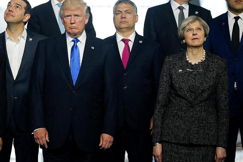 (Front row, from left) Greek Prime Minister Alexis Tsipras, US President Donald Trump, Hungarian Prime Minister Viktor Orban and Britain's Prime Minister Theresa May standing in line for a group photo at the start of the Nato summit in Brussels yeste