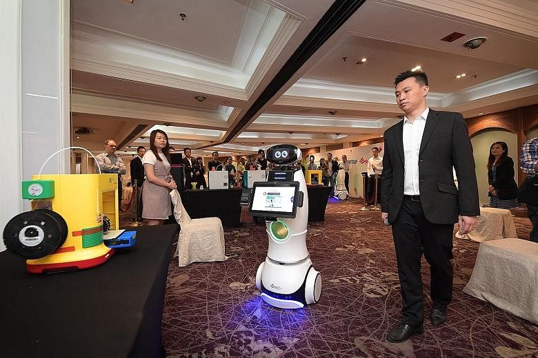 The XYZrobot showing visitors what it can do at Marina Mandarin Hotel yesterday. The retail robot was launched along with 3D desktop printers by Newstead Technologies.