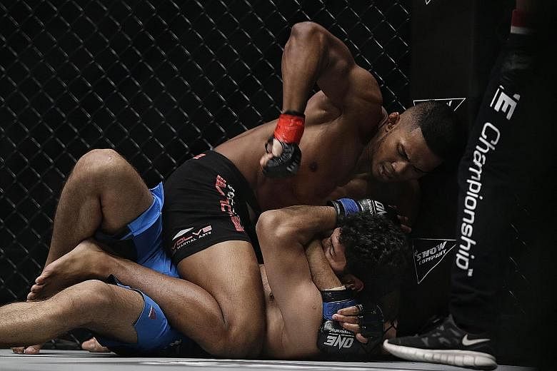 Singapore's mixed martial arts fighter Amir Khan pummelling India's Rajinder Singh Meena on his way to scoring a technical knockout win last night at One Championship's Dynasty of Heroes event held at the Singapore Indoor Stadium. Khan, 22, represent