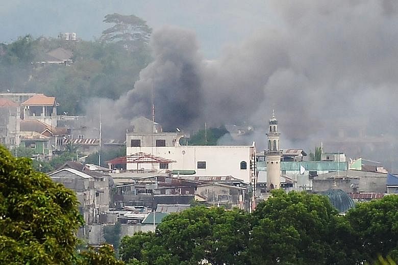 Residential areas in Marawi on fire after military helicopters fired rockets targeting Muslim extremists on Thursday. An army brigade has been sent to dislodge them, but they remained holed up in parts of the mainly Muslim city last night.