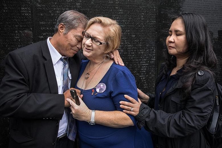 Mr Vu Ngoc Xiem with Ms Susan Mitchell-Mattera and Ms Nguyen Thi Hong Diem at the Vietnam Veterans Memorial in Washington on Thursday. The two women are children of people who died in the Vietnam war.