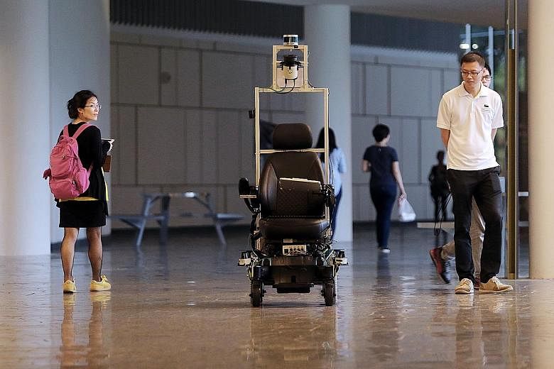 The self-driving wheelchair moving along a mapped-out route at the National University of Singapore. It was piloted at Changi General Hospital last September.