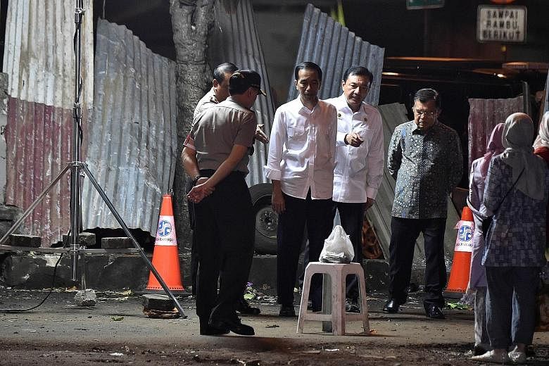 (From third from left) President Joko Widodo, State Intelligence Agency chief Budi Gunawan, and Indonesian Vice-President Jusuf Kalla at the bomb blast site at the Kampung Melayu bus station in Jakarta on Thursday.