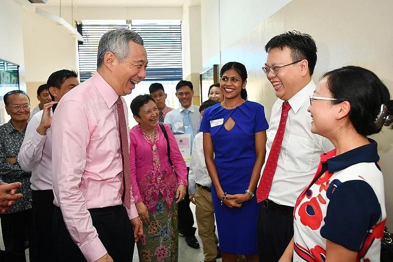 Prime Minister Lee Hsien Loong with new citizens - Singapore Airlines air stewardess Kavitha Sathekoma, 28; IT director Donny Liu, 41, and his wife Tina Chen, 35, a finance manager - at the end of the Ang Mo Kio GRC-Sengkang West SMC Citizenship Cere