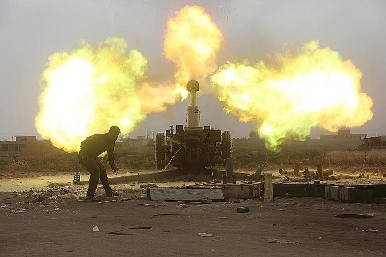 Popular Mobilisation Forces personnel firing at ISIS militants during a battle on the outskirts of Al-Ba'aj, west of Mosul, on Friday. The United States-backed offensive on Mosul, now in its eighth month, has taken longer than planned as the militant