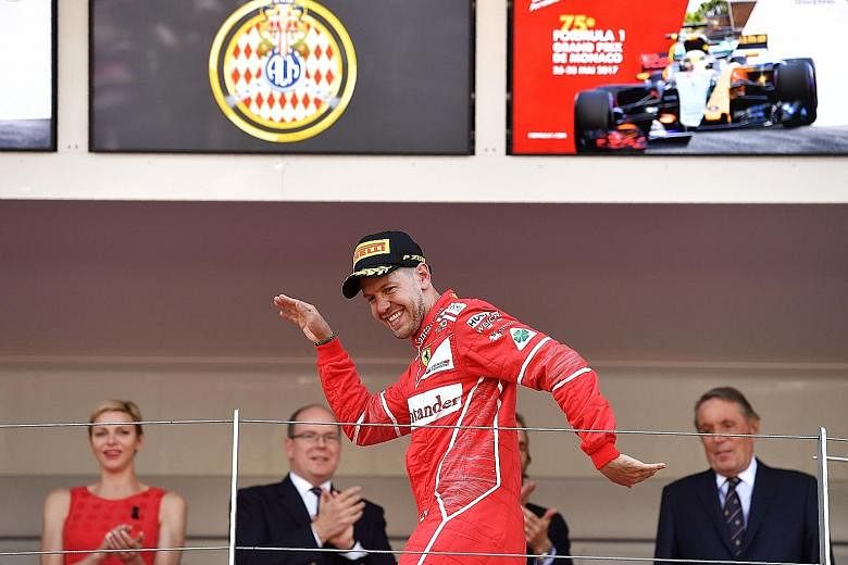 Ferrari's Sebastian Vettel celebrating on the podium after winning in Monaco, watched by Prince Albert II, Princess Charlene and other dignitaries.