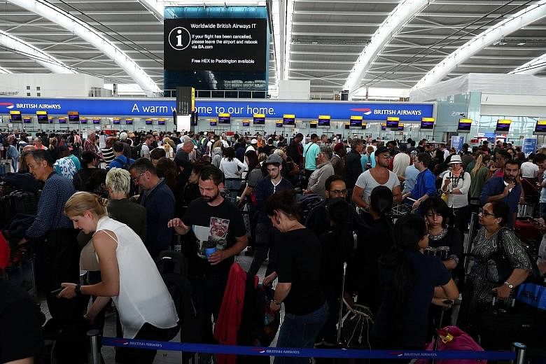 Passengers waiting at Heathrow Airport's Terminal 5 yesterday. Thousands were stranded after hundreds of BA flights at Heathrow and Gatwick were affected by the IT outage.