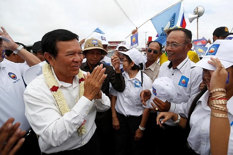 Mr Kem Sokha, leader of the opposition Cambodia National Rescue Party, greeting supporters during a campaign rally in Prey Veng province yesterday.