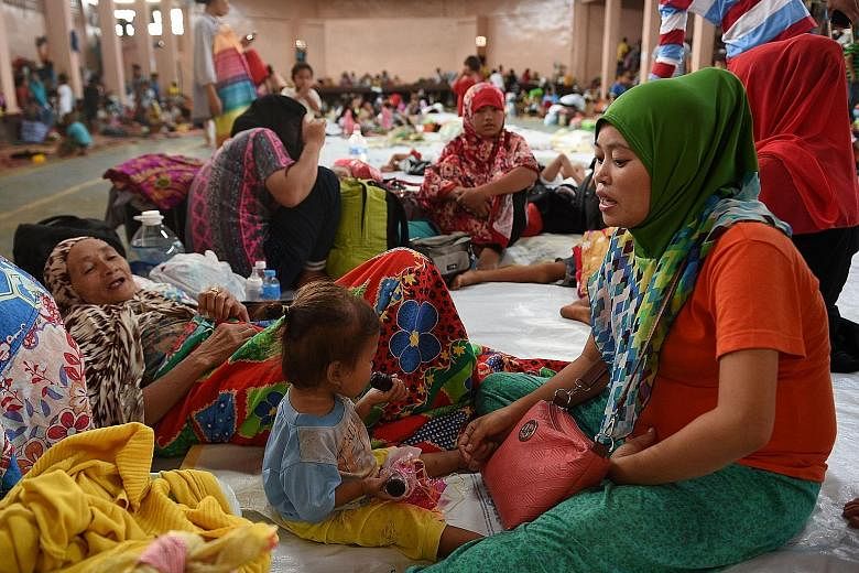 A family from Marawi resting at an evacuation centre in Balo-i, Mindanao, yesterday. Many more locals are stuck in their homes and are afraid to venture out for fear that militants roaming the streets would kill them or take them hostage.