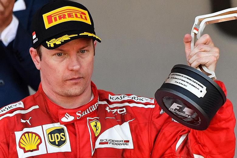 Kimi Raikkonen is stony-faced as he lifts his trophy after finishing second to team-mate Sebastian Vettel in the Monaco Grand Prix on Sunday. The Finn led the prestigious street race for the first 33 laps.
