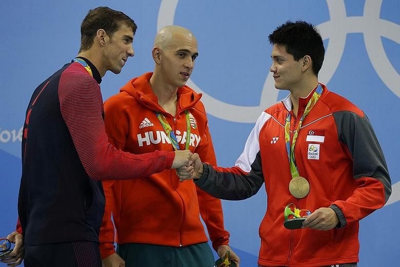 American Michael Phelps, the greatest swimmer in history, congratulating Olympic champion Joseph Schooling, as Hungary's Laszlo Cseh looks on after the men's 100m butterfly final. Chad le Clos also shared the silver.